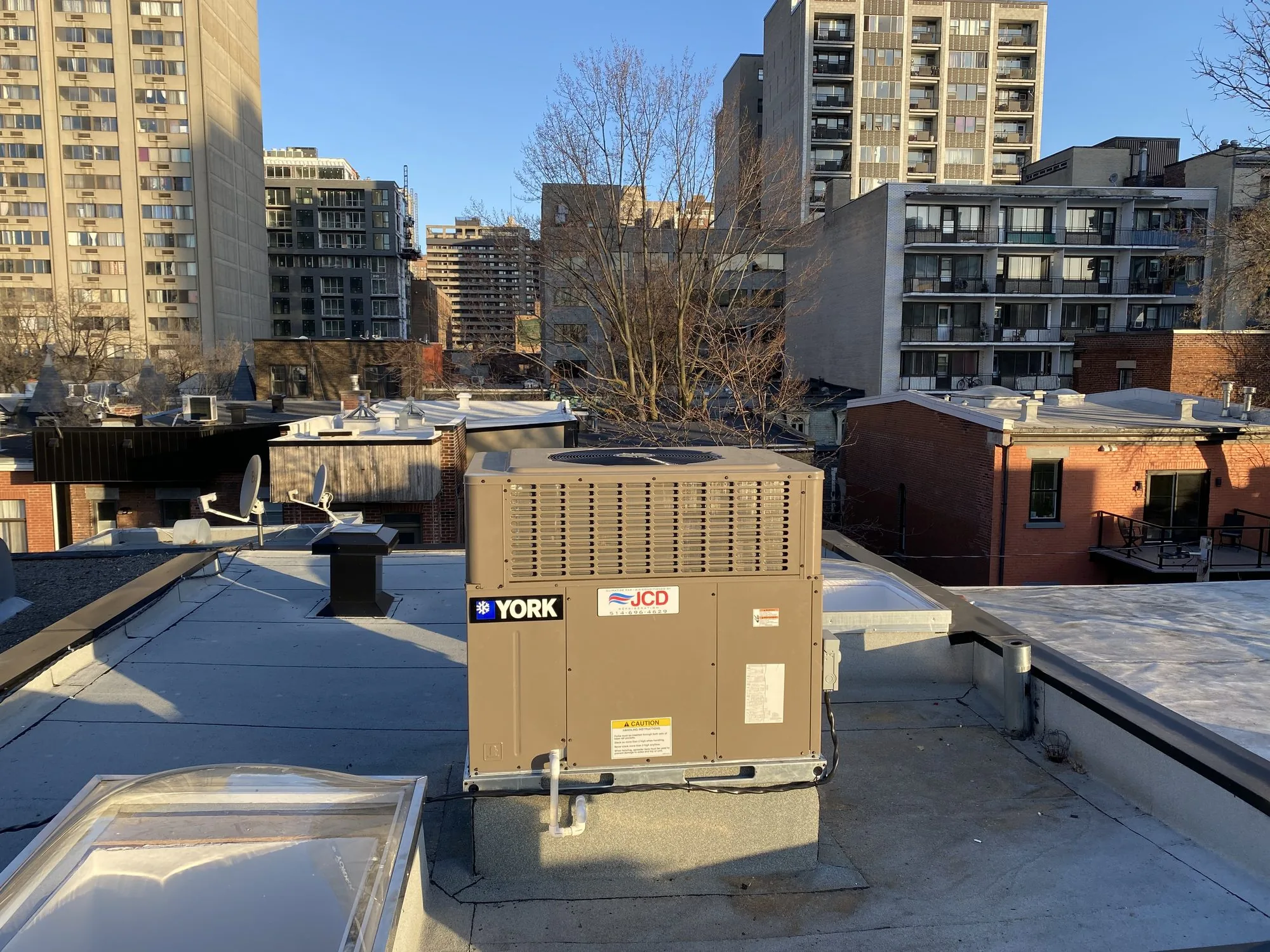 A York rooftop unit with a JCD sticker, on a downtown roof